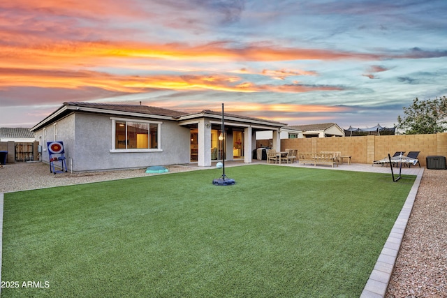 back of property with a yard, stucco siding, fence, and a patio