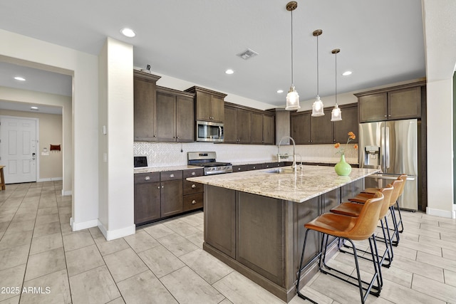 kitchen with visible vents, dark brown cabinetry, a sink, and stainless steel appliances