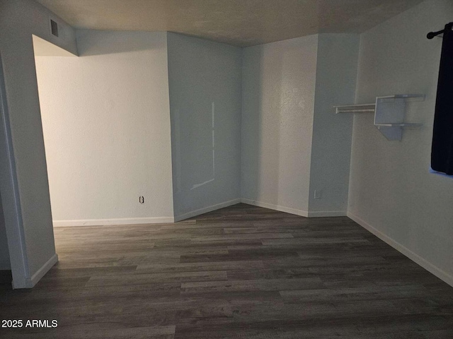 unfurnished room featuring visible vents, baseboards, and wood finished floors