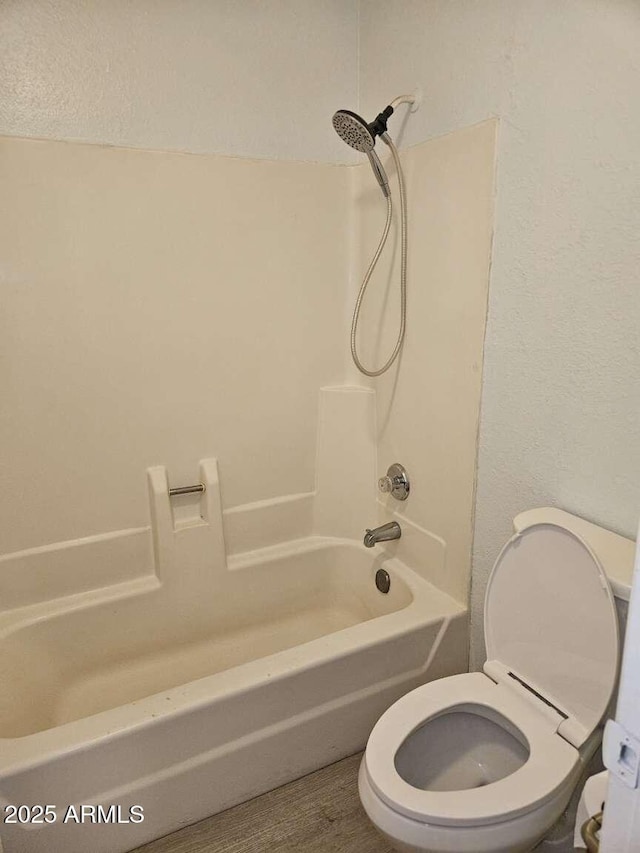 bathroom with tub / shower combination and toilet