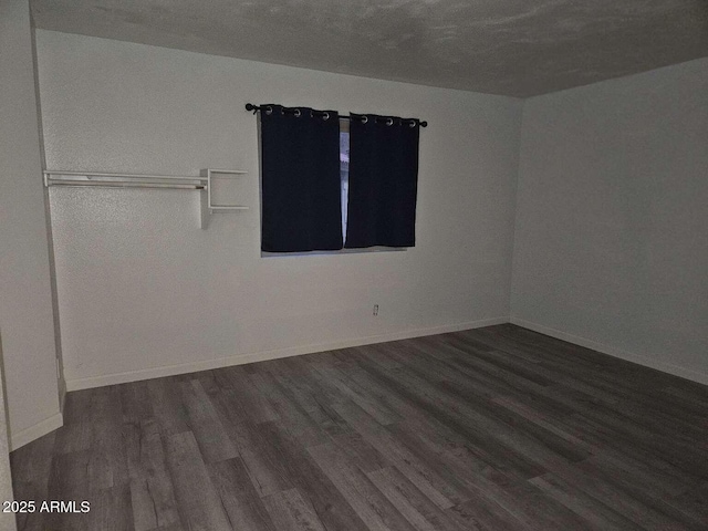 spare room with wood finished floors and baseboards