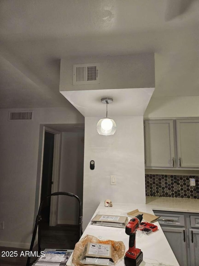 kitchen with visible vents, light countertops, decorative backsplash, and gray cabinetry