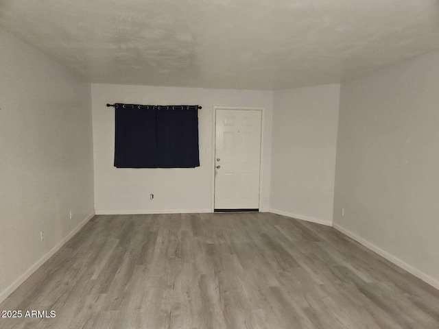 unfurnished room featuring baseboards and wood finished floors