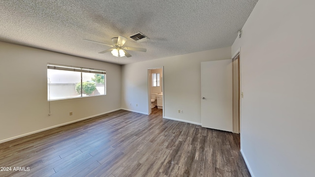 unfurnished bedroom featuring ceiling fan, ensuite bath, dark hardwood / wood-style flooring, and a textured ceiling