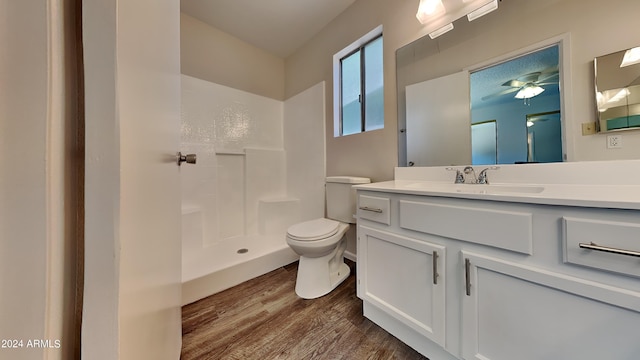 bathroom featuring vanity, hardwood / wood-style flooring, a shower, and toilet