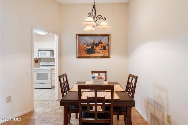 dining space with an inviting chandelier and light parquet flooring