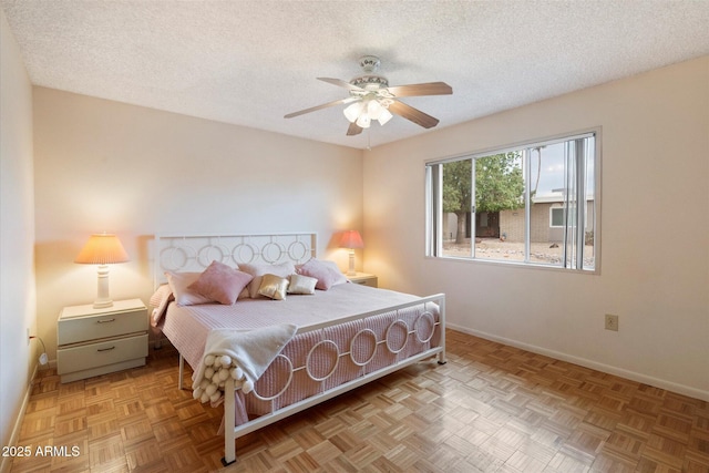 bedroom with ceiling fan, a textured ceiling, and light parquet floors