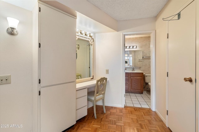 bathroom featuring vanity, parquet floors, a textured ceiling, and toilet