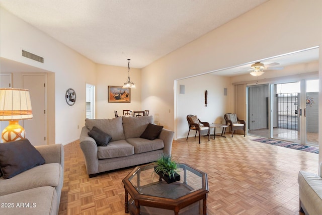 living room with ceiling fan with notable chandelier and light parquet floors