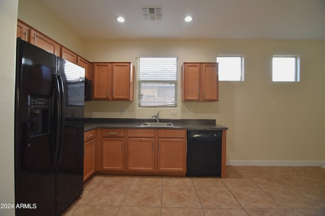 kitchen featuring light tile flooring, sink, and black appliances