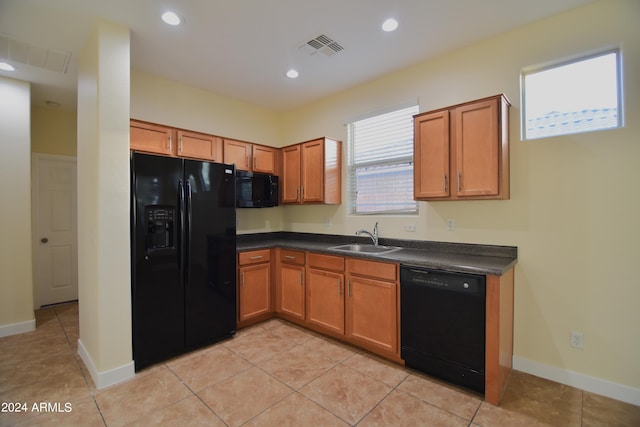 kitchen with light tile floors, black appliances, and sink