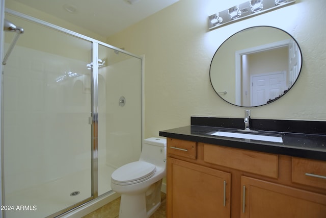 bathroom with toilet, tile floors, a shower with shower door, and vanity