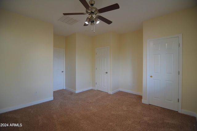 spare room with ceiling fan and light colored carpet