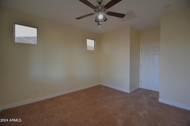 carpeted spare room featuring ceiling fan