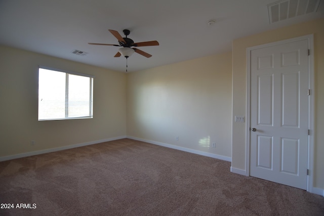 carpeted spare room with ceiling fan