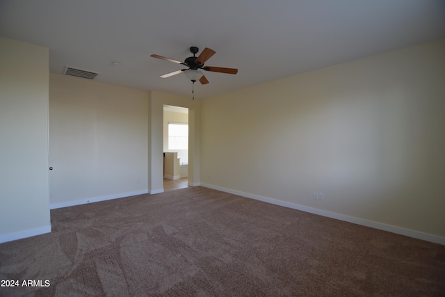 empty room featuring dark carpet and ceiling fan