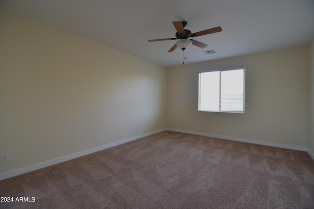 spare room featuring light colored carpet and ceiling fan