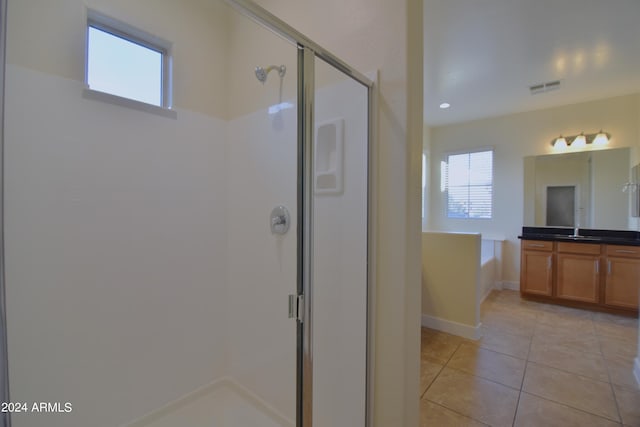 bathroom with tile flooring, walk in shower, and vanity