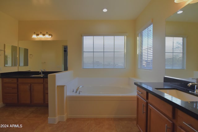 bathroom featuring tile floors, dual vanity, and a bathtub