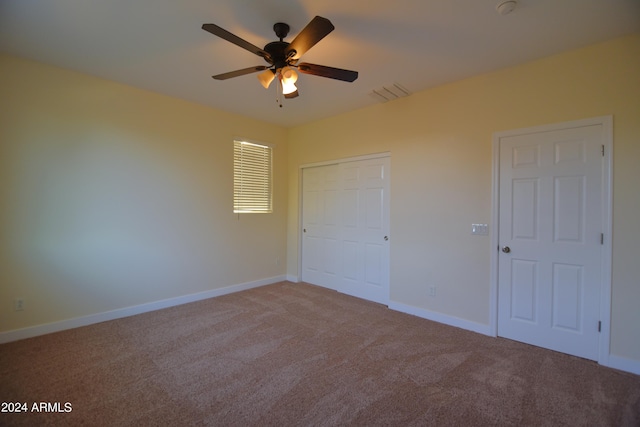 unfurnished bedroom featuring ceiling fan, light colored carpet, and a closet