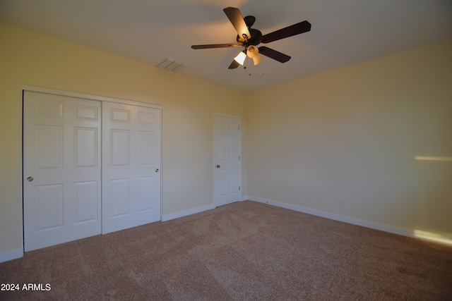 unfurnished bedroom featuring carpet floors, a closet, and ceiling fan