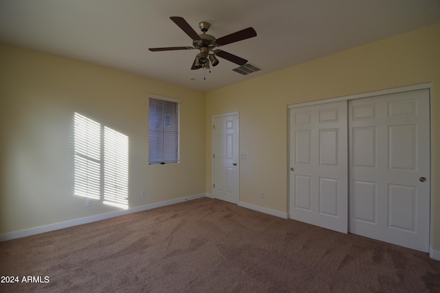 unfurnished bedroom featuring ceiling fan, carpet, and a closet