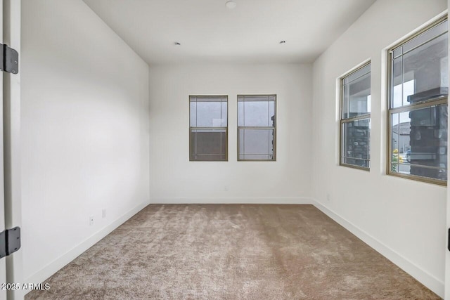 unfurnished room featuring baseboards and carpet