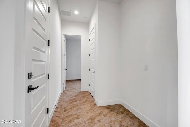 hallway featuring visible vents and baseboards