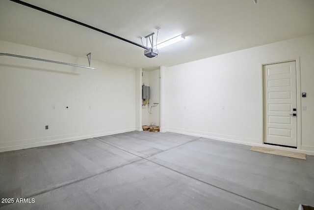 garage featuring a garage door opener and baseboards