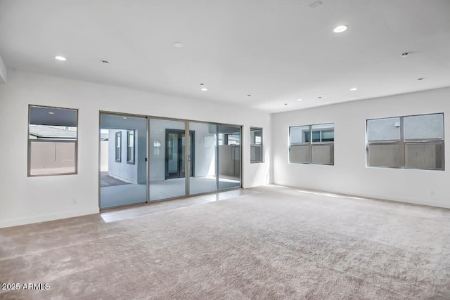 carpeted empty room featuring recessed lighting, baseboards, and a healthy amount of sunlight