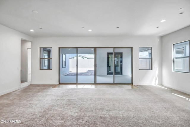 carpeted spare room with recessed lighting, baseboards, and tile patterned floors