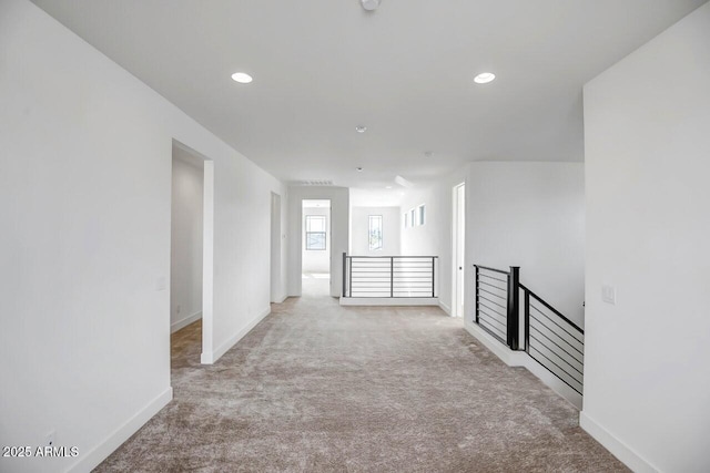 hall featuring an upstairs landing, carpet flooring, recessed lighting, and baseboards