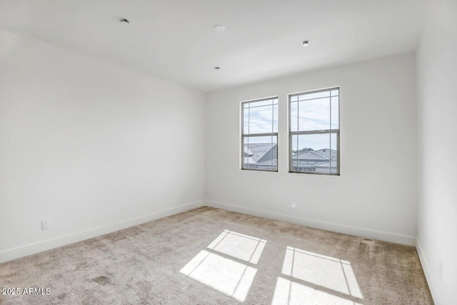 unfurnished room with carpet and baseboards