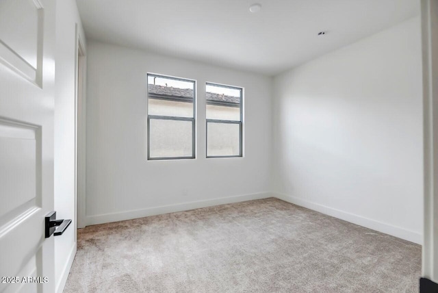 spare room featuring baseboards and carpet flooring