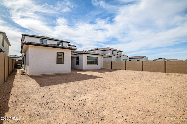 back of house featuring stucco siding and a fenced backyard