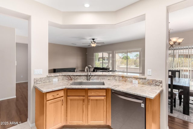 kitchen featuring ceiling fan with notable chandelier, dishwasher, sink, light stone counters, and kitchen peninsula