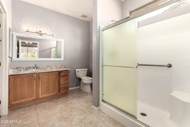 bathroom featuring tile patterned flooring, vanity, a shower with door, and toilet