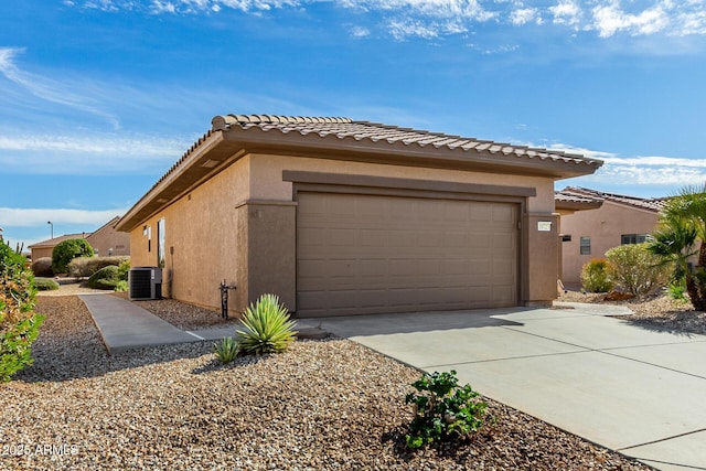 view of side of home featuring a garage and central AC unit