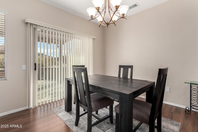 dining area with an inviting chandelier and dark hardwood / wood-style floors