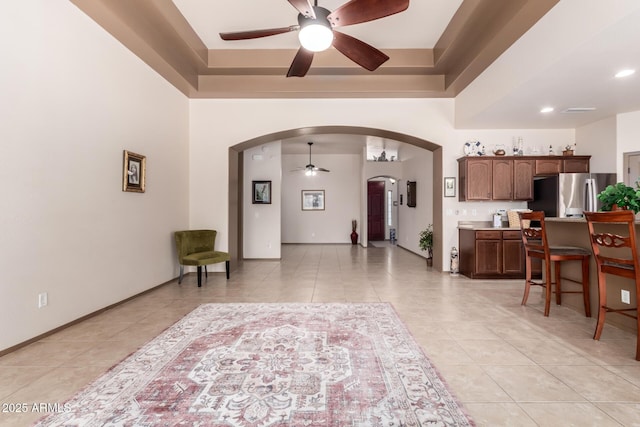 interior space featuring a raised ceiling and ceiling fan