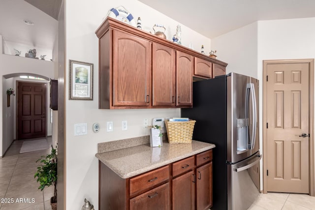 kitchen featuring stainless steel refrigerator with ice dispenser and light tile patterned floors