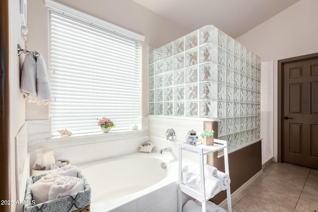 bathroom with tile patterned floors and tiled bath