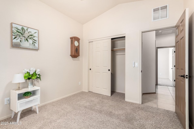 unfurnished bedroom featuring light carpet, lofted ceiling, and a closet