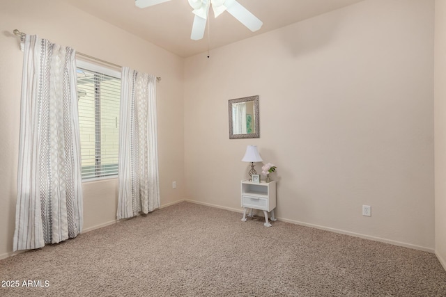 carpeted spare room featuring ceiling fan