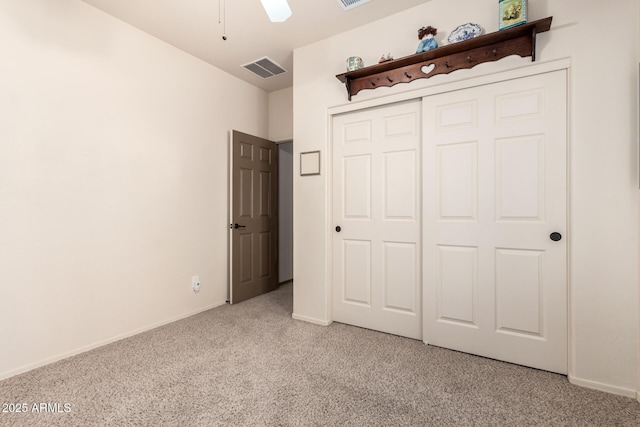 unfurnished bedroom featuring light carpet and a closet