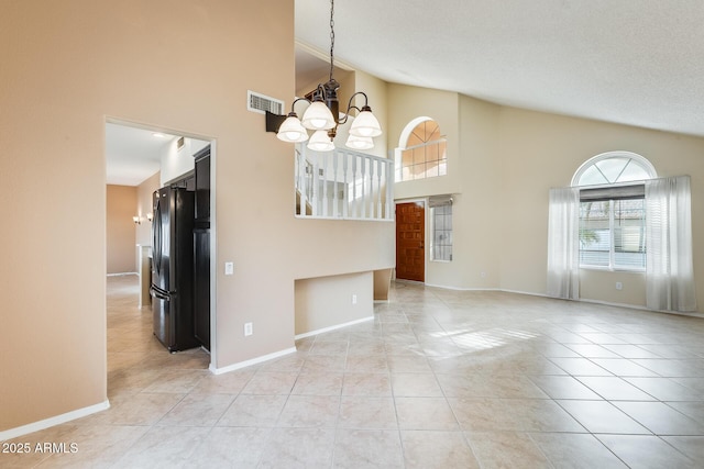 interior space with light tile patterned floors, a notable chandelier, and high vaulted ceiling