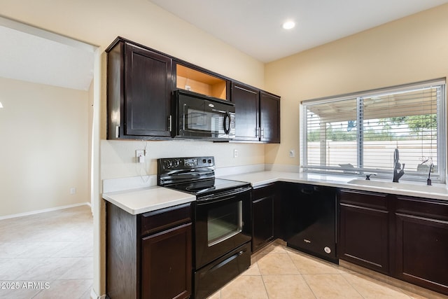 kitchen featuring light tile patterned flooring, dark brown cabinets, sink, and black appliances