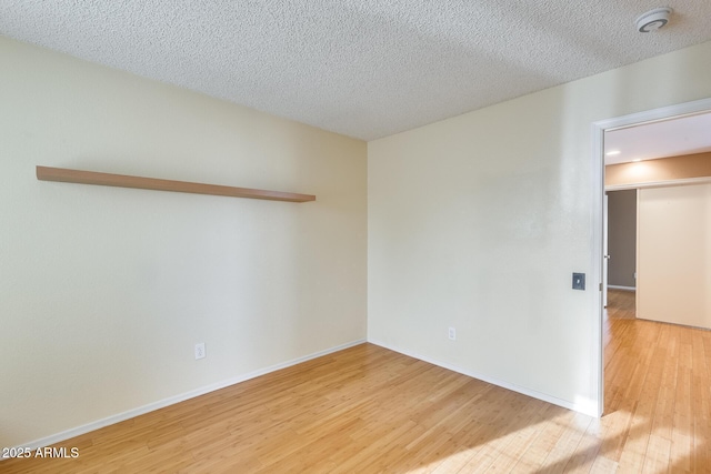 empty room featuring hardwood / wood-style flooring and a textured ceiling