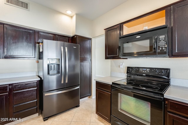 kitchen featuring light tile patterned flooring, dark brown cabinetry, and black appliances