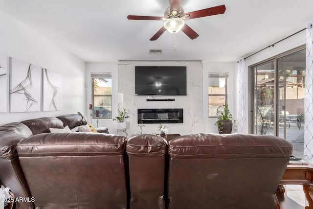 living room with a fireplace and ceiling fan